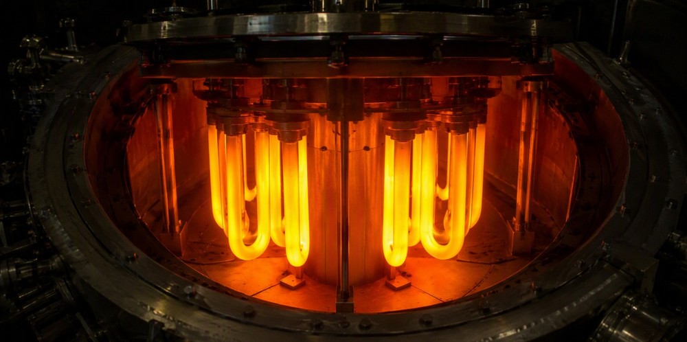 Glowing U-shaped silicon slim rods depositing inside a hot bell-jar vapor deposition reactor.