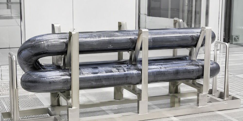 A pair of thick harvested polysilicon rods resting on a metal handling frame in a cleanroom.