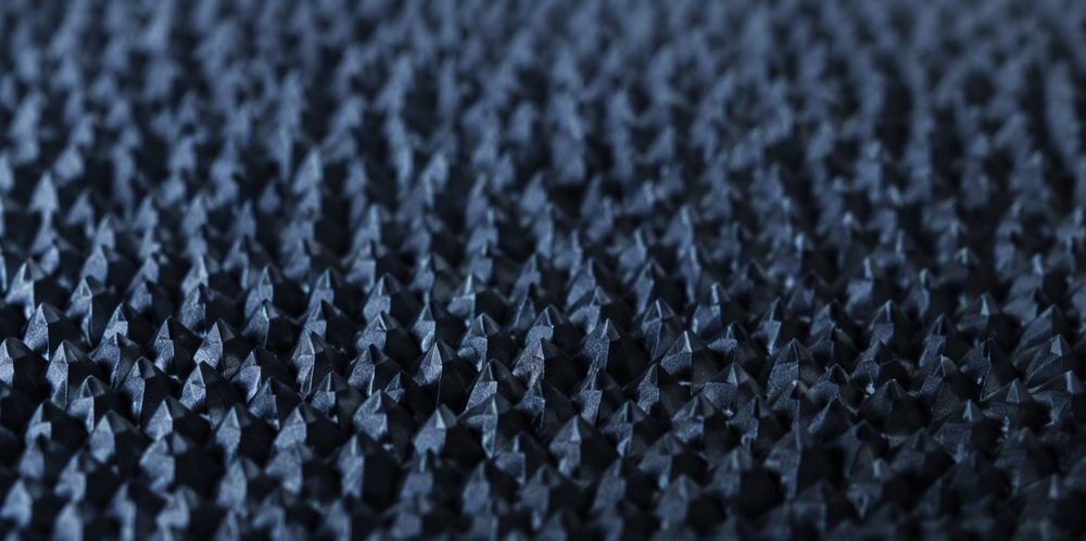 A close view of countless tiny pyramids etched across a textured monocrystalline wafer surface.