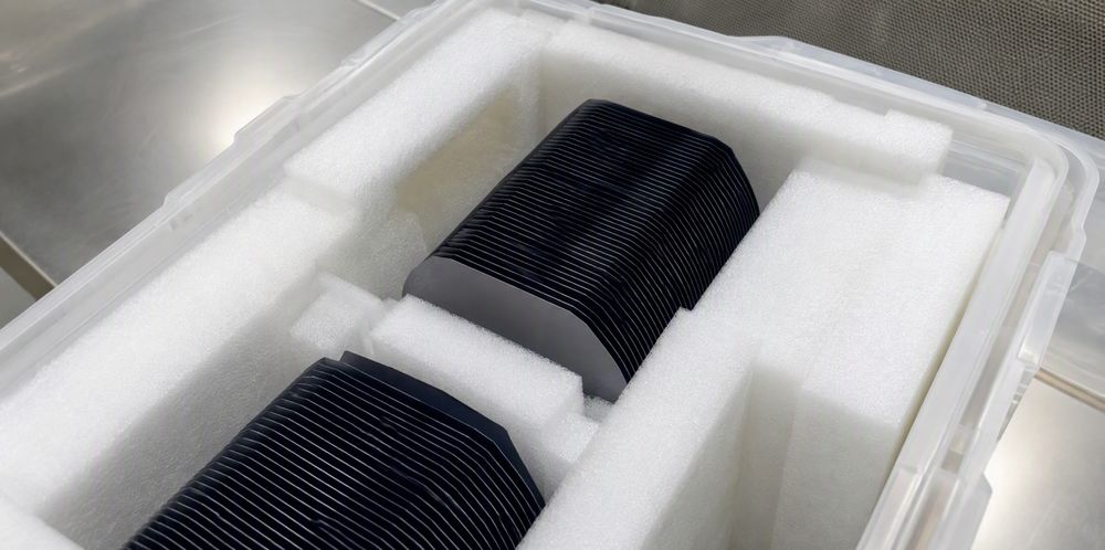 Wrapped stacks of solar wafers cushioned in white foam inside an open shipping box.