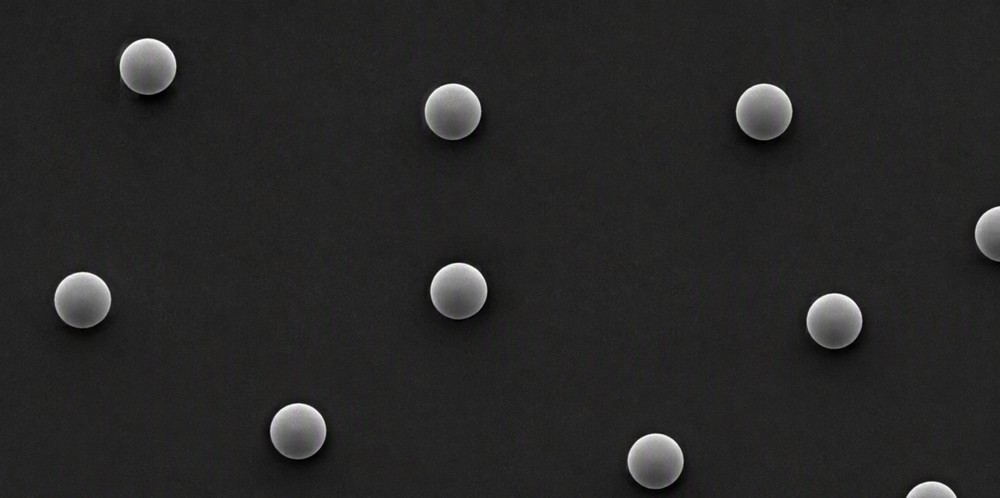 A grayscale electron micrograph of well-separated uniform nanospheres on a dark field.