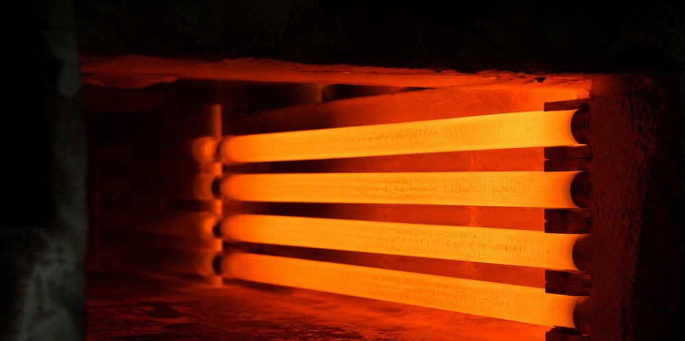 Rod-shaped heating elements glowing orange inside a dark furnace chamber.