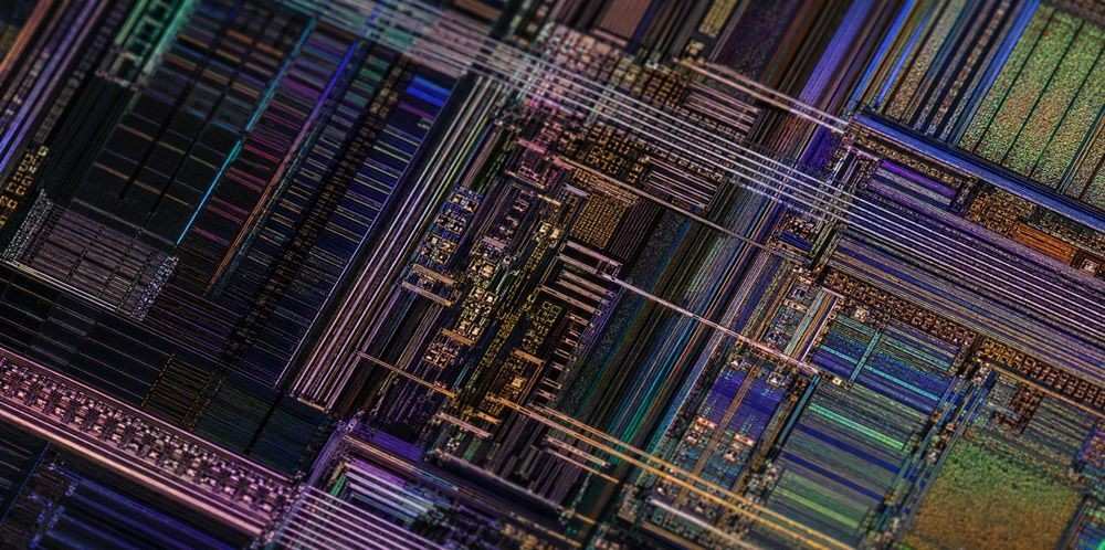 An extreme close-up of a microchip surface patterned with fine metallic lines.