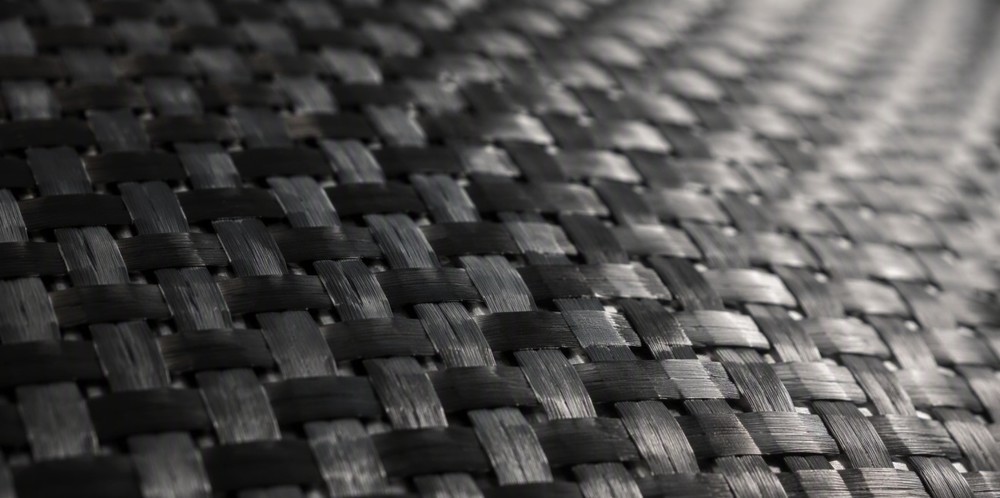 A close-up of dark woven ceramic fiber fabric with a fine grid texture.