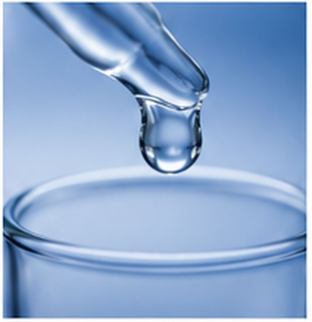 Single droplet of clear silicone fluid suspended above a smooth glass surface.
