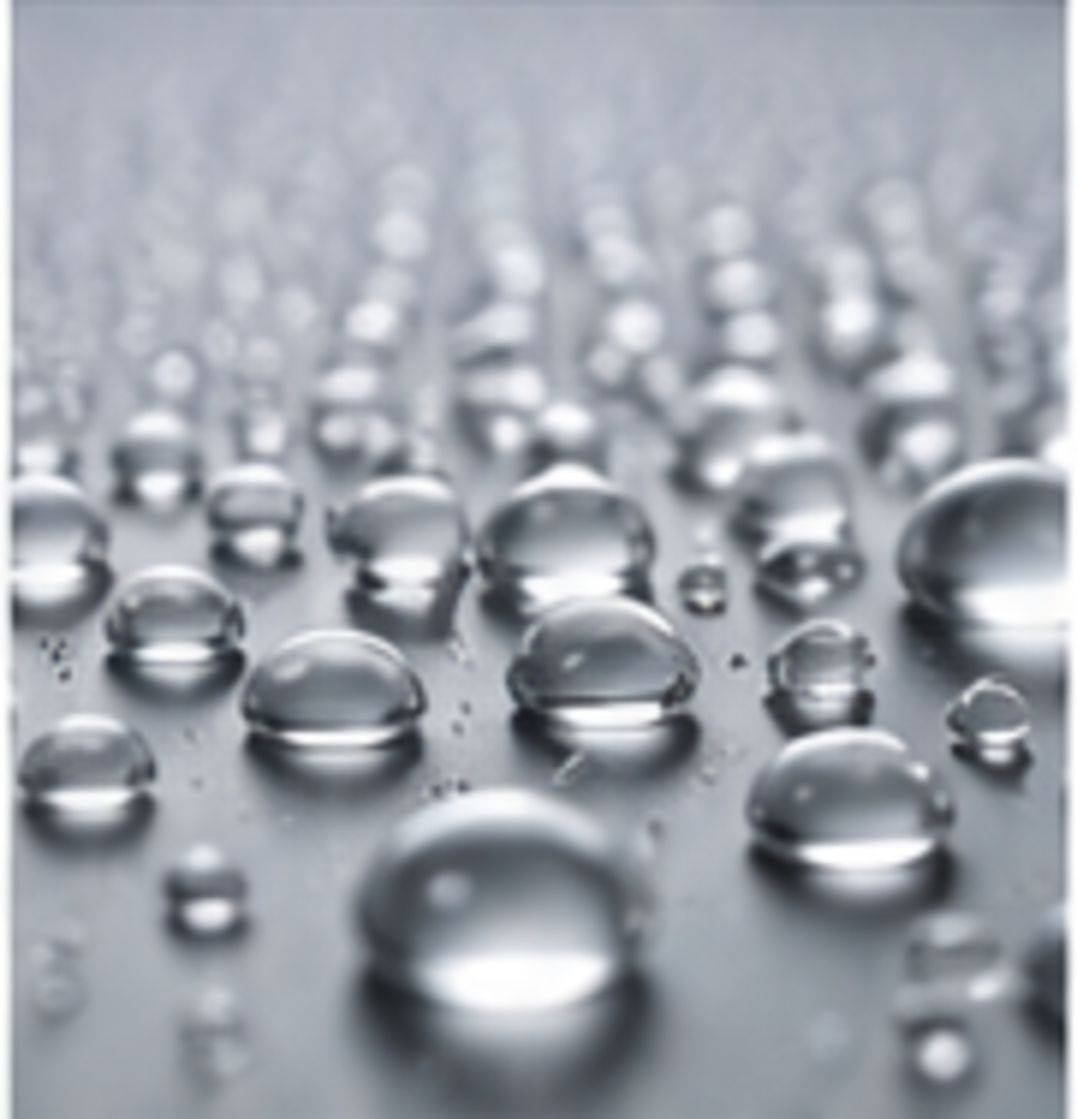 Reflective microdroplets distributed across a metallic surface to represent low-surface-tension wetting behavior.