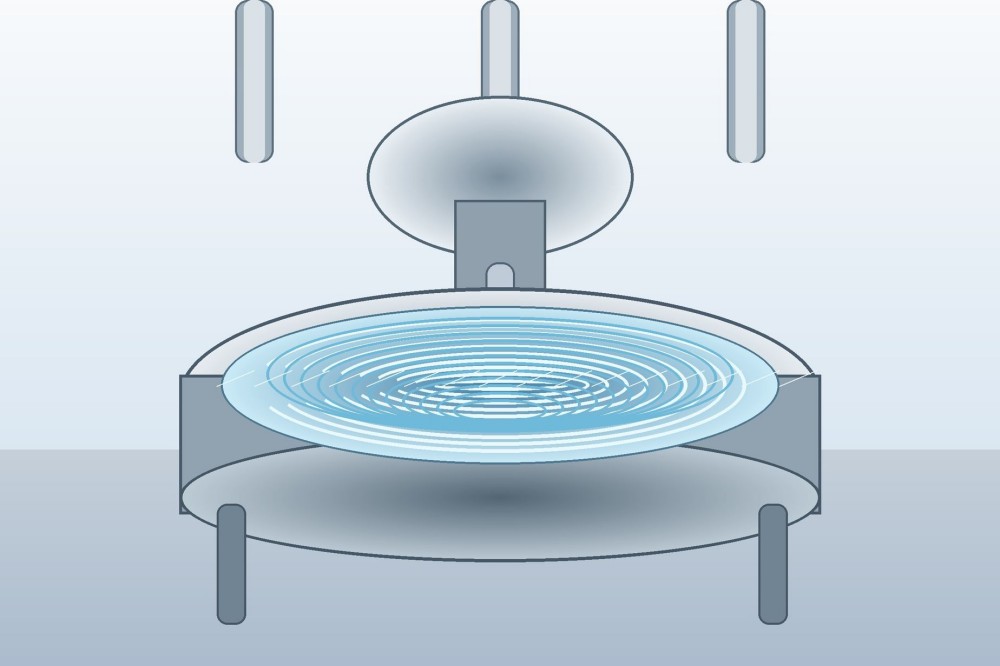 High-resolution view of clear reactive silicone fluid swirling in a polished industrial mixing vessel.