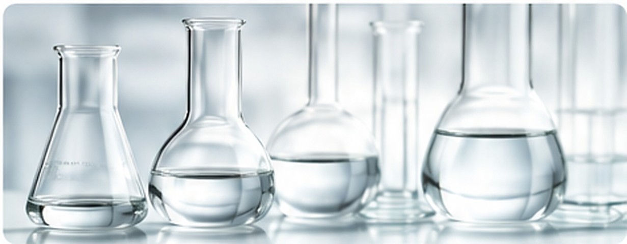 Several unlabelled laboratory flasks hold clear silicone-fluid samples on a bright bench.