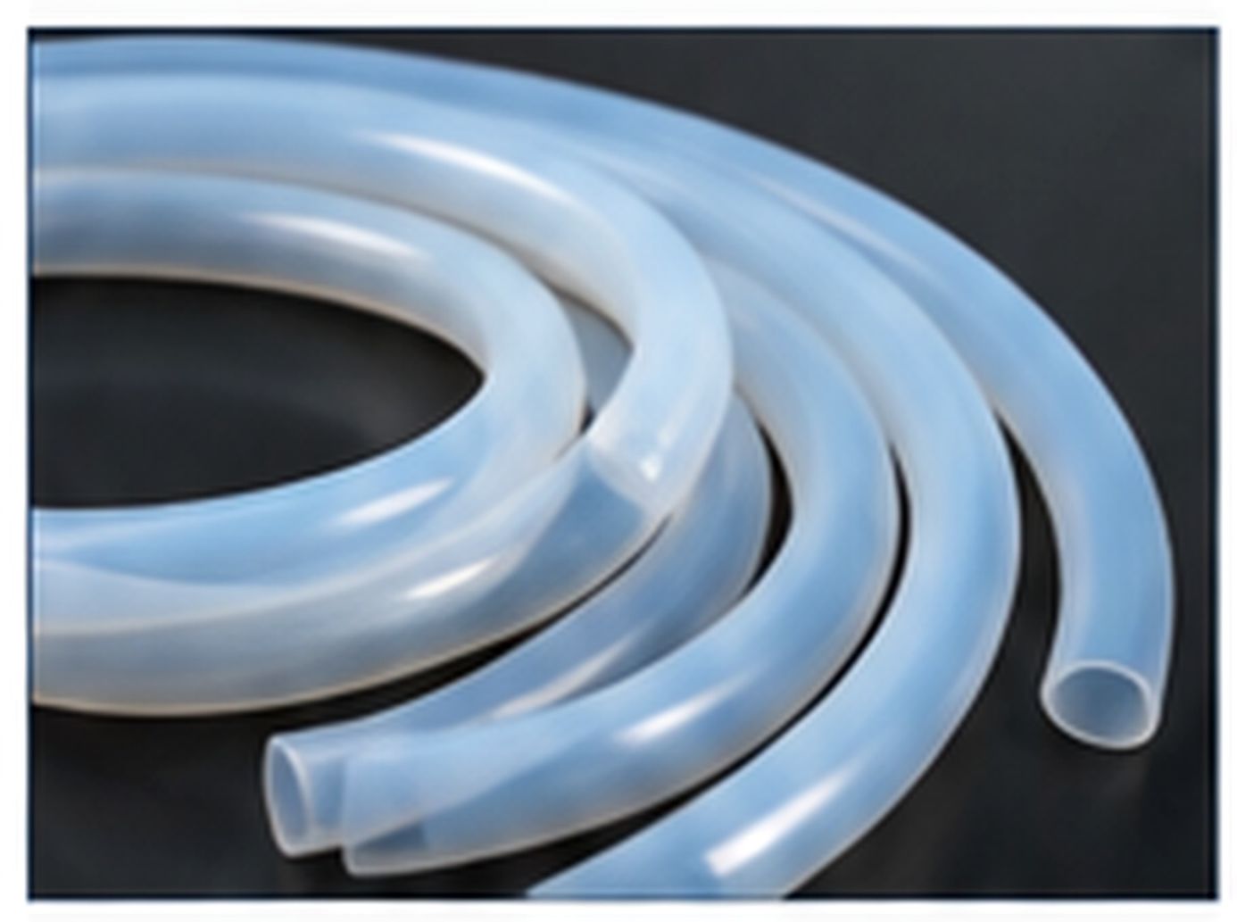 Coiled translucent silicone tubing with smooth round walls and open ends.