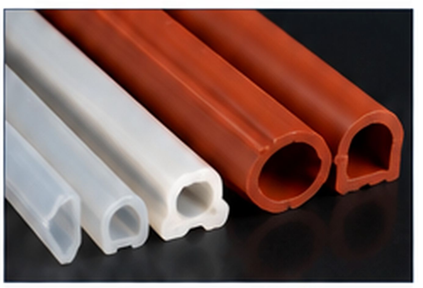 White and orange extruded silicone profiles with multiple hollow cross-section shapes.