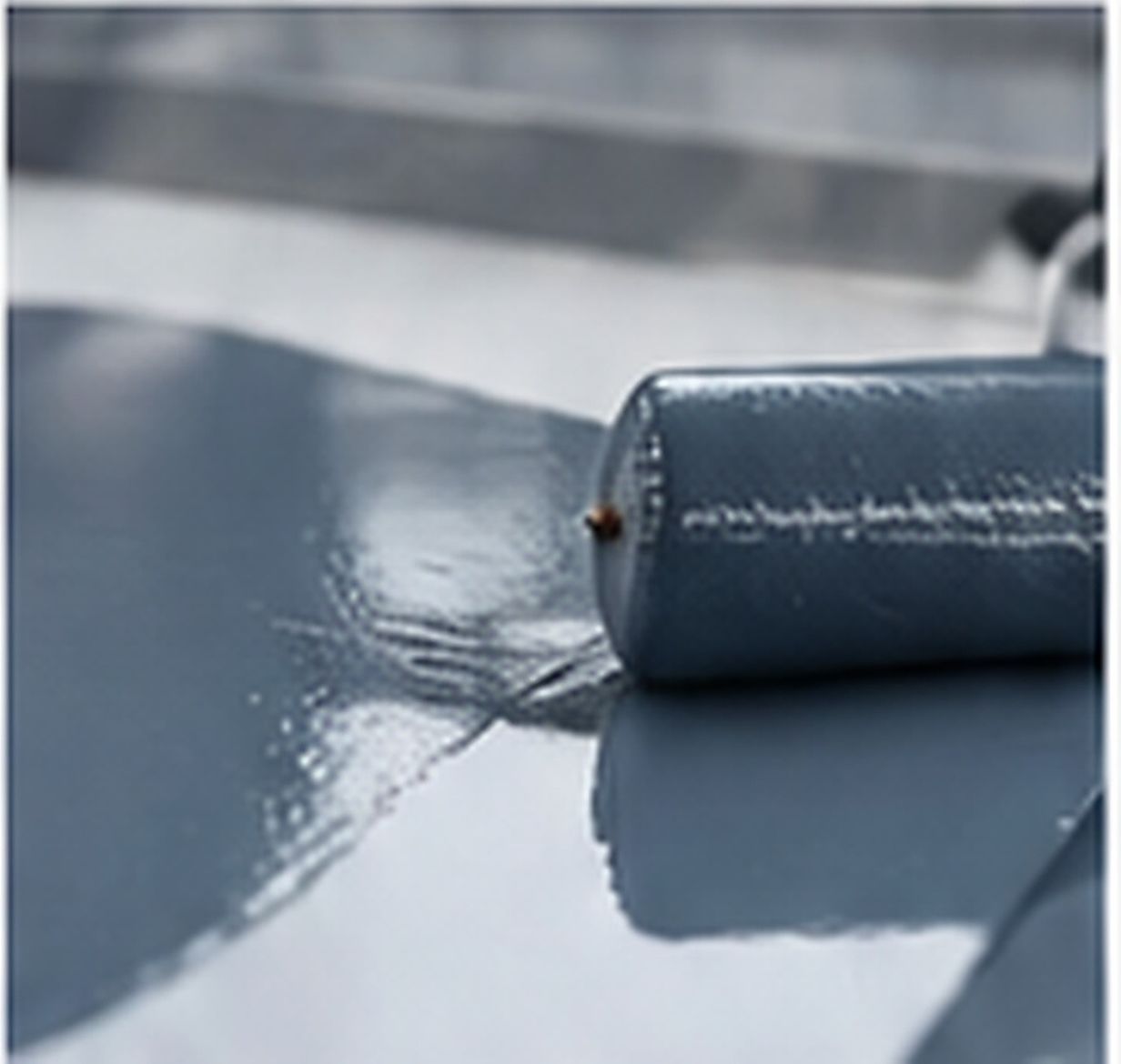 Transparent silicone resin coating spread evenly across a smooth industrial substrate for protective surface applications.