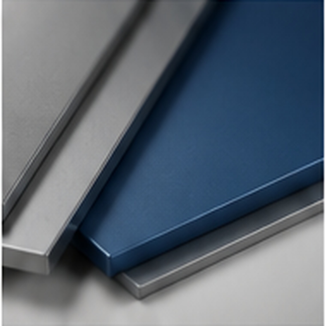 Stacked coated metal panels in blue and silver tones representing broad substrate compatibility.