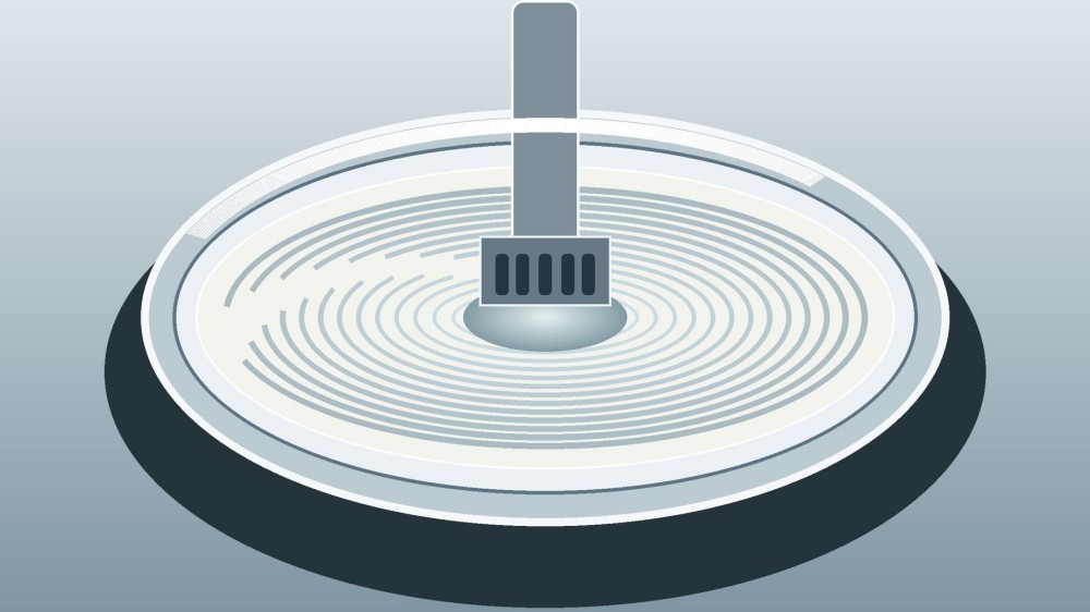 A rotor-stator mixer forms a centered vortex inside a stainless vessel filled with a pale emulsion.