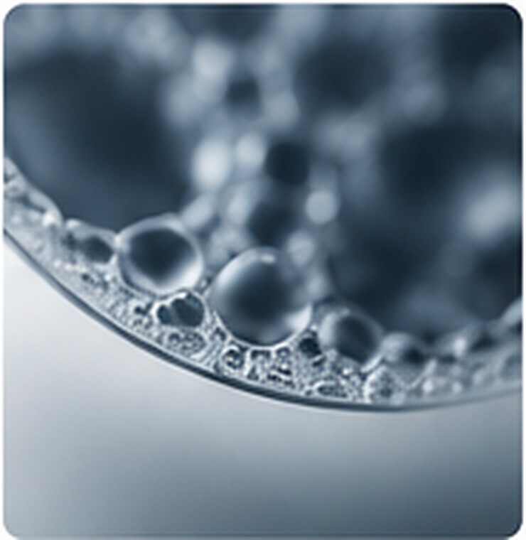 Close-up of small droplets at a curved interface representing stable multi-phase dispersion.