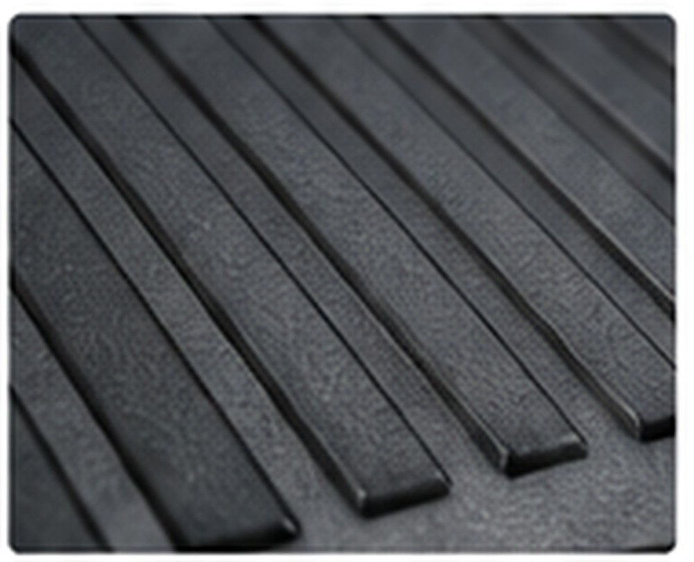 Black textured industrial surface with parallel raised ribs for abrasion-resistant applications.